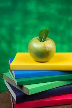 Apple fruit on top of a book stack, on the back of school classes. photo