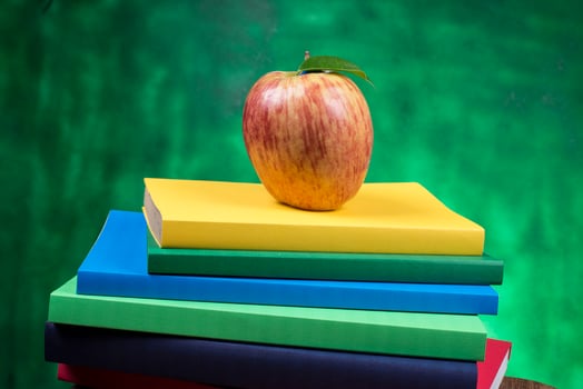 Apple fruit on top of a book stack, on the back of school classes. photo