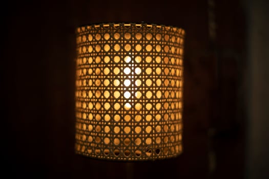Lamp in dark. Wooden lampshade around incandescent lamp. photo