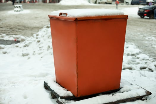 Steel tank. Dumpster. Place to store sand on highway. Orange object in winter on road. photo