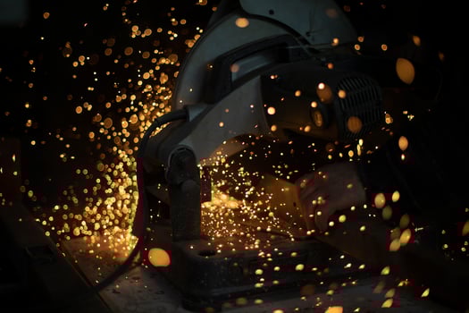 Saw cuts metal. Sparks from friction. Lot of sparks from sawing steel. photo