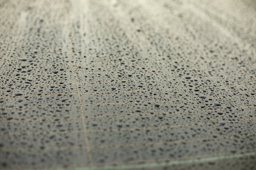 Drops of water on black surface. Car parts in rain. photo