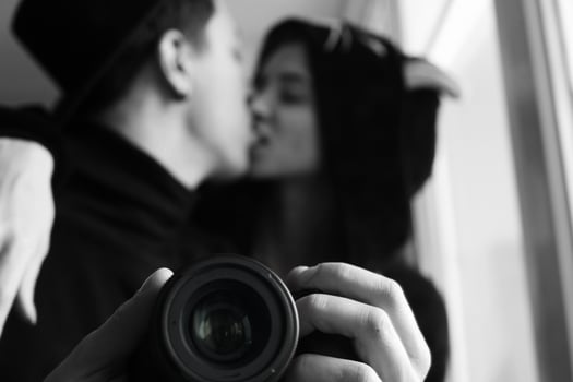 man and woman in black clothes kissing photo