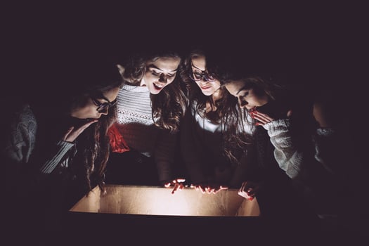 Sisters opens a box with a Christmas present and fascinated looks inside photo