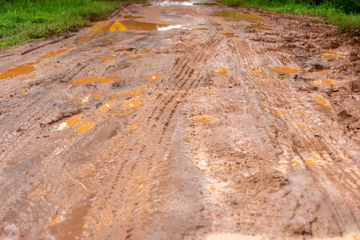 dirt road The red ground, and the country roads, were soaked in water from the heavy rain.Difficult roads, inconvenient traffic photo