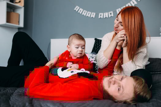 Happy family with newborn baby on the bed photo