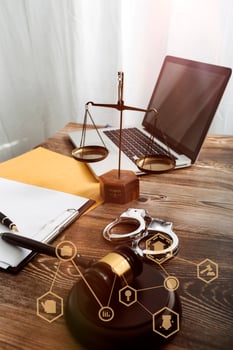 Justice and law concept.Male judge in a courtroom with the gavel, working with, computer and docking keyboard, eyeglasses, on table in morning light photo