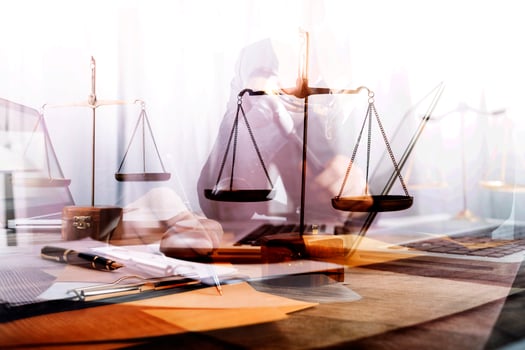 Justice and law concept.Male judge in a courtroom with the gavel, working with, computer and docking keyboard, eyeglasses, on table in morning light photo
