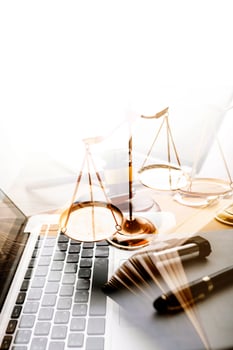 Justice and law concept.Male judge in a courtroom with the gavel, working with, computer and docking keyboard, eyeglasses, on table in morning light photo