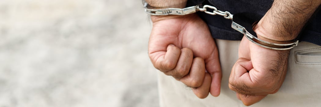 Prisoner male criminal standing in handcuffs with hands behind back photo