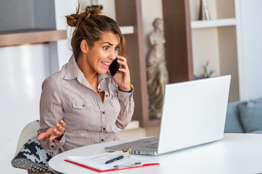 Confused customer calling support service at office. Outraged young female employee talking by phone. photo