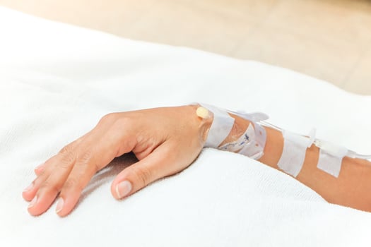 Close up saline drip in patient's hand in hospital photo