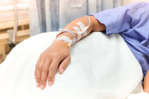 Close up of saline drip in patient's hand . Asian woman with  hospital admission. photo