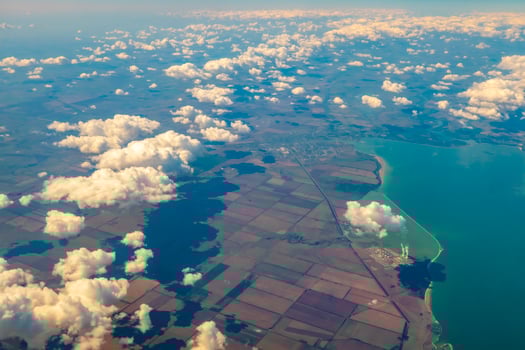 Aerial photo of Farmland. view from the plane to the ground. squares of fields under the clouds