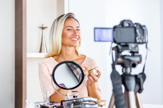 Beautiful natural woman professional beauty vlogger or blogger live broadcasting cosmetic makeup tutorial viral video clip by camera sharing on social media photo