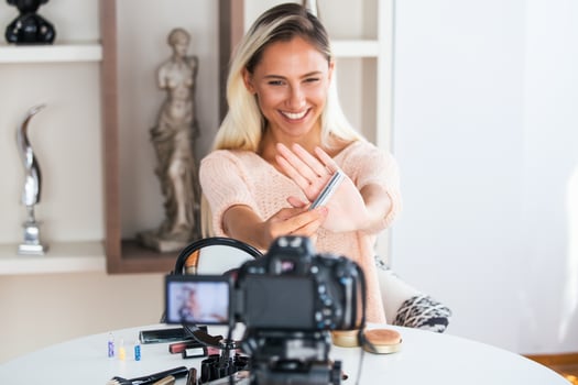 Beautiful natural woman professional beauty vlogger or blogger live broadcasting cosmetic makeup tutorial viral video clip by camera sharing on social media photo