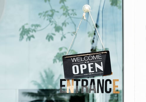 Hanging sign with message WELCOME OPEN on glass door at coffee shop photo