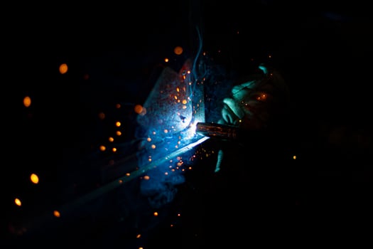 Metal welding. Fire from operation of welding machine. Manufacture of steel seam. Processing of steel profile. Sparks from welding. photo