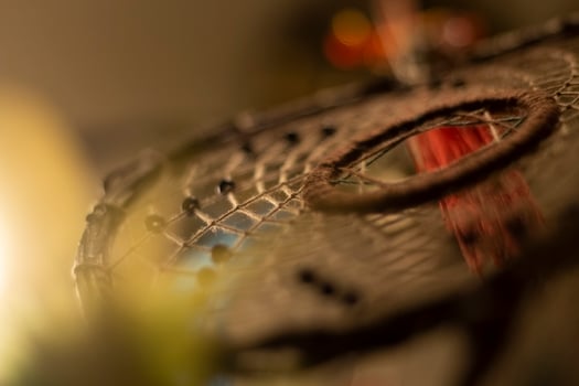 Dreamcatcher in interior. Details of Indian amulet for good sleep. Object woven from threads. Symbol of peace in house. photo