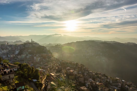 Sun rays hitting a city on a hill photo