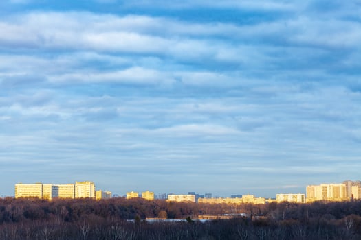 dark blue clouds over urban park at spring sunset photo