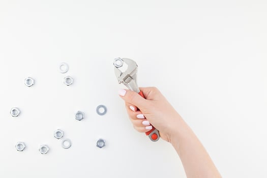 Female hand holding spanner on white background photo