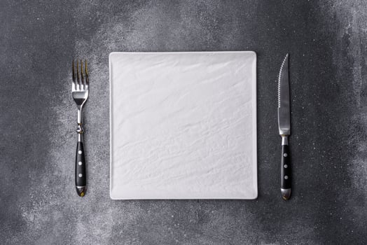 Empty square white plate on a gray moody background with copy space photo