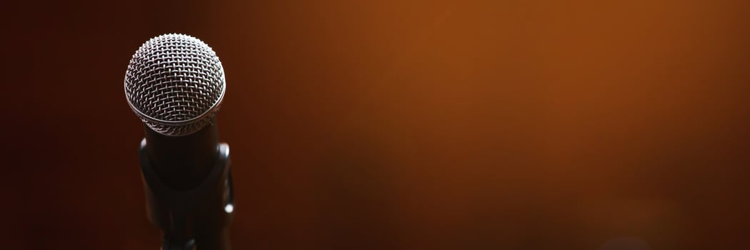 Close up of microphone on stage lighting at concert hall or conference room. copy space banner. soft focus. photo