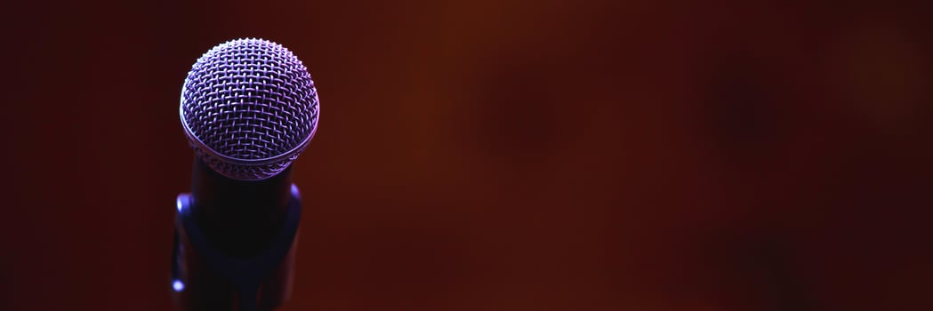 Close up of microphone on stage lighting at concert hall or conference room. copy space banner. soft focus. photo