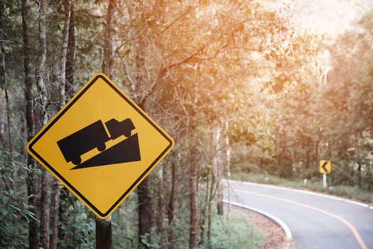 Traffic sign, beware of trucks on a curved road photo