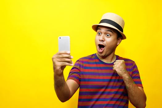 Happy man wins special bonus from online product sweepstakes in phone photo