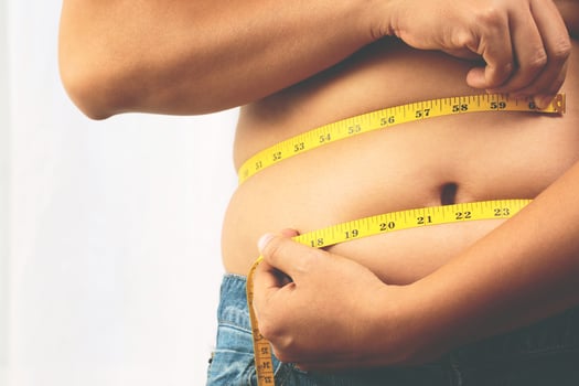 fat man check out body overweight abdomen his belly with in hand measuring tape f photo