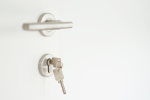 house key on home shaped key chain silver keyring in the lock of a door. concept for buying real estate agent housing and apartment. photo