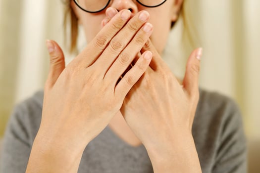 A disgusted girl is checking her breath. photo
