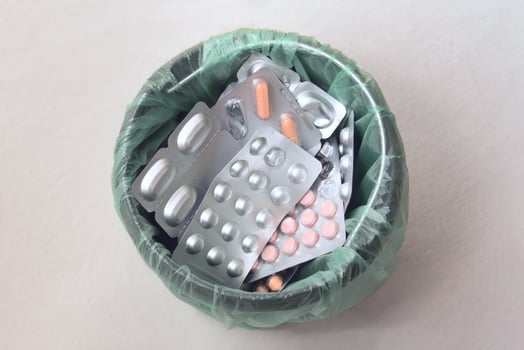 Trash bin with medical pills. Waste of different packages of medicines. Top view photo