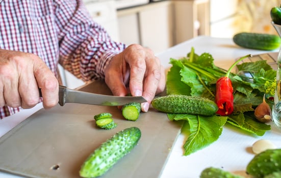 Modern male hands cutting cucumber salad, great design for any purpose. Fresh organic vegetable. Business concept. Modern design. Cooking healthy wholesome food. photo