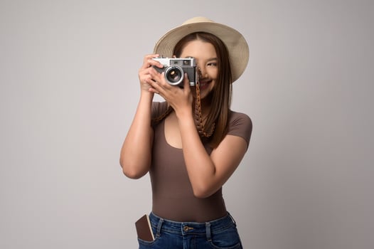 Young happy asian tourist woman over white background studio, travel and holidays concept. photo