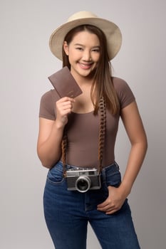 Young happy asian tourist woman over white background studio, travel and holidays concept. photo