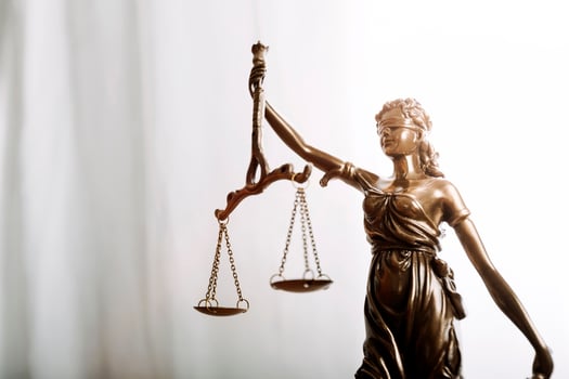 Justice and law concept.Male judge in a courtroom with the gavel, working with, computer and docking keyboard, eyeglasses, on table in morning light photo