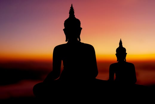 buddha silhouette on golden sunset background beliefs of Buddhism photo