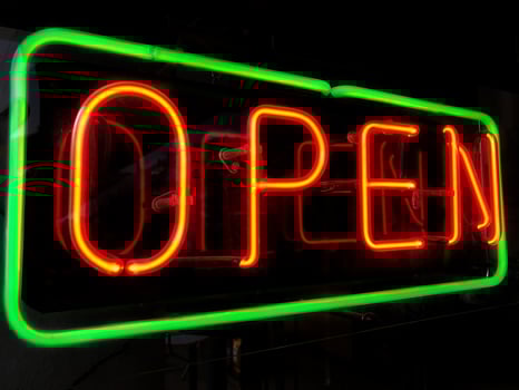 open neon sign in shop window at night photo