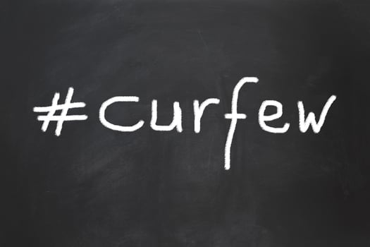 hashtag curfew as handwritten text on chalkboard photo
