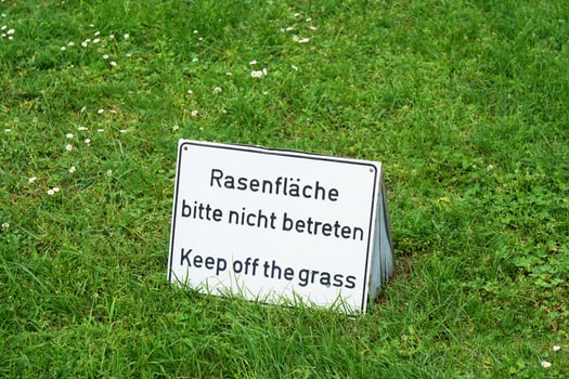 bilingual keep of the grass sign in Germany photo