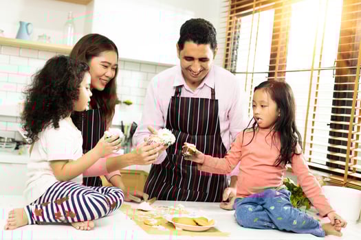 Group of four Diverse Family, Asian and Arab Preschool African Arab kid person make Cake cooking in kitchen, Father Mother prepare decoration pretty with fun educate. Cream mess over face, copy space photo