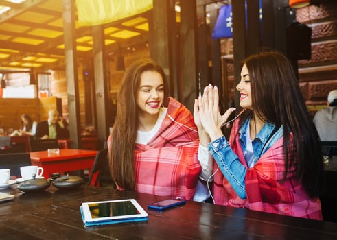 Two young and beautiful girls having fun in cafe photo