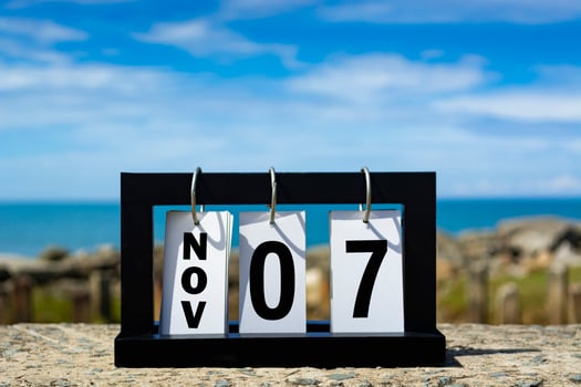 Nov 07 calendar date text on wooden frame with blurred background of ocean. photo