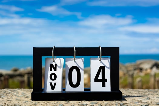 Nov 04 calendar date text on wooden frame with blurred background of ocean. photo