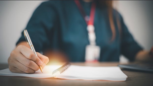 Business Woman Writing with pen in notepad photo