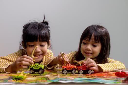 Little children's siblings play with toys on the table. photo