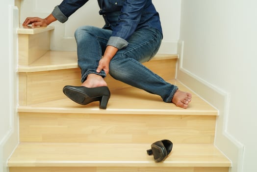 Asian business woman pain ankle, foot with leg cramp and fall down the stairs because slippery surfaces in office. photo